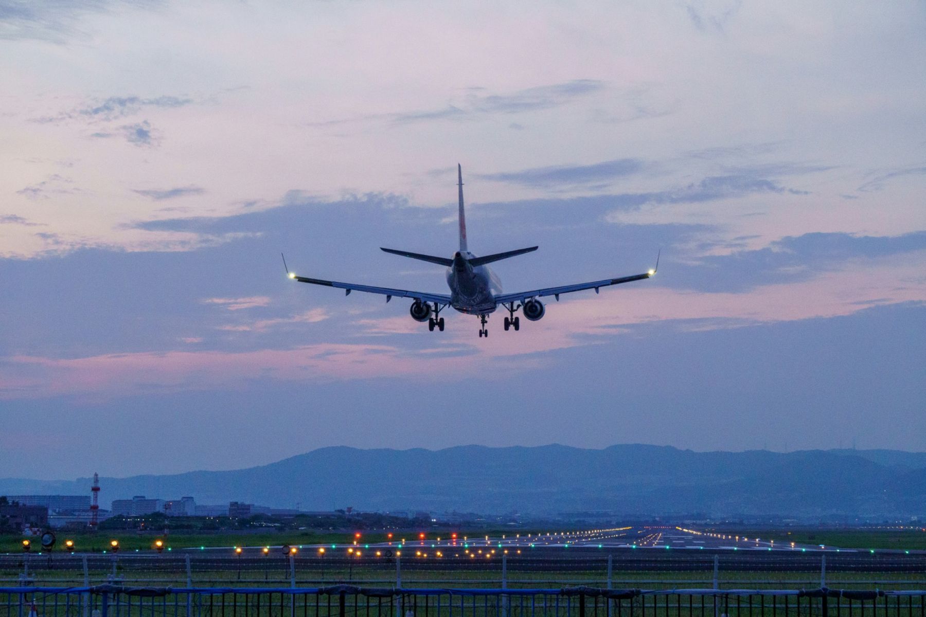Passenger aircraft approaching a runway at dusk